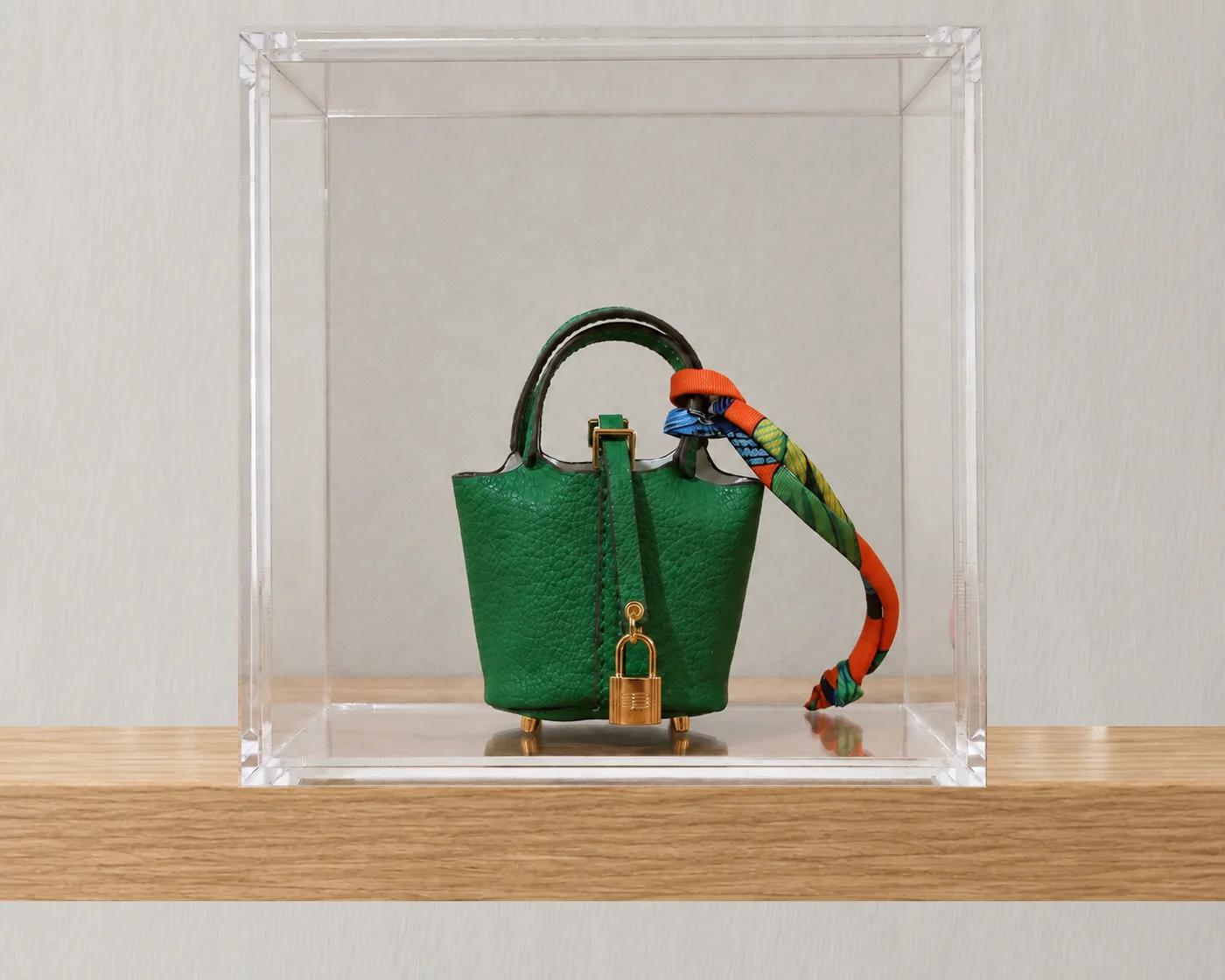 Mini bolsa decorativa verde em moldura de acrílico transparente, da linha Ícones